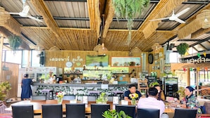 Un restaurant avec un plafond en bambou, des tables et des chaises en bois.