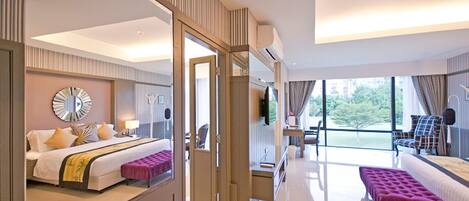 Una habitación de hotel moderna con una cama grande, una zona de estar con un banco, un televisor y un balcón con vistas.