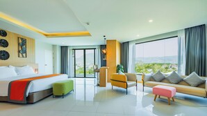 Une chambre d’hôtel moderne, dotée d’un grand lit, d’un canapé, d’une petite table et offrant une vue sur l’extérieur.