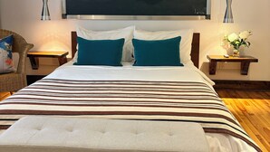 A bedroom with a large bed, two bedside tables, a wall-mounted air conditioner, and a painting of rocks. - Loft Jacques-Cartier- Le Plateau Free Parking (Montreal)