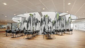 Ein geräumiger Konferenzraum mit modernem Deckenstil, einer großen Wandmalerei und Holzboden.