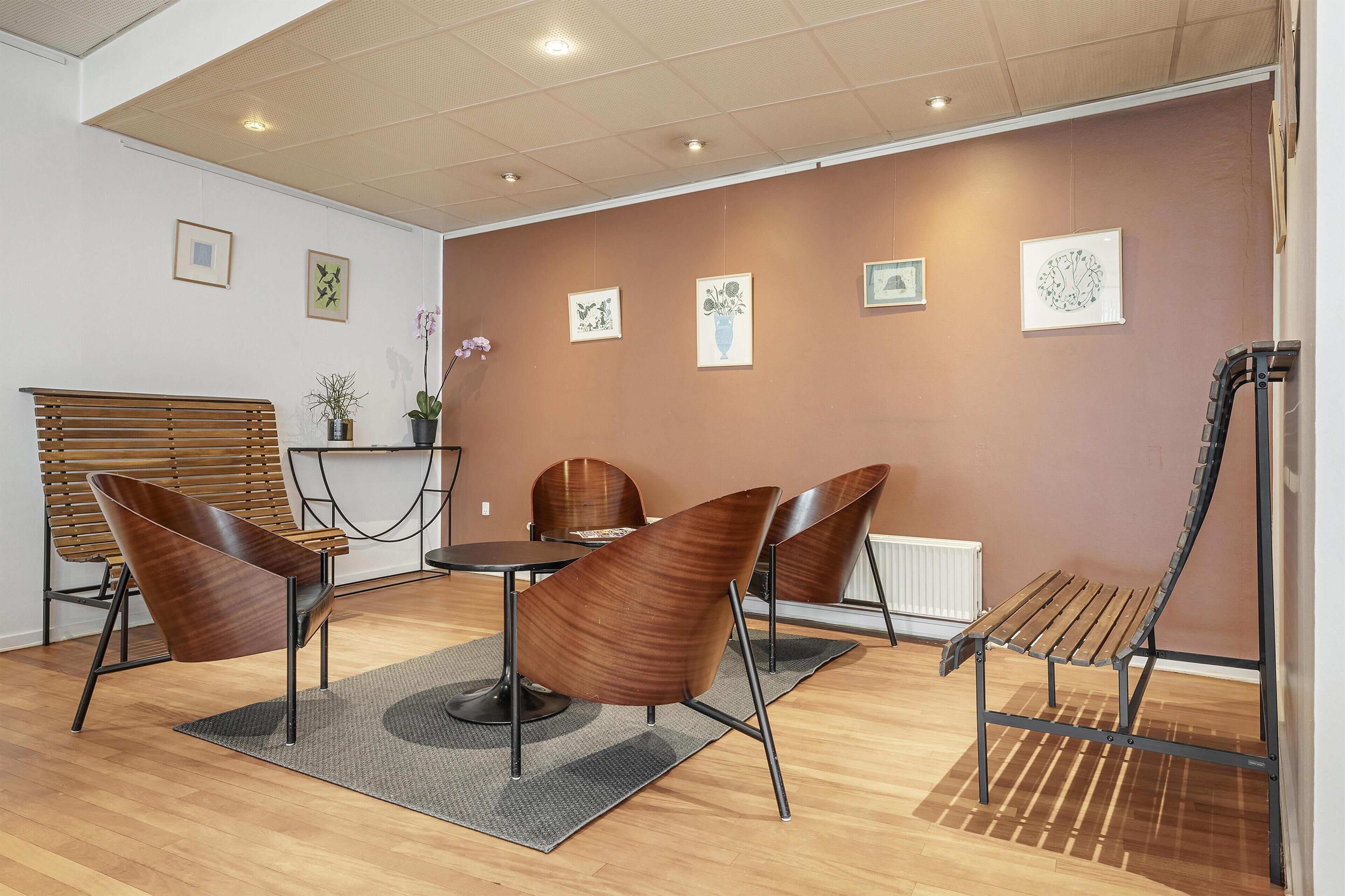 A modern interior with a wooden bench, a round table, and chairs.