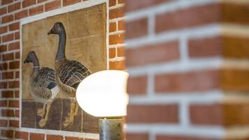 A mural of two geese on a brick wall.