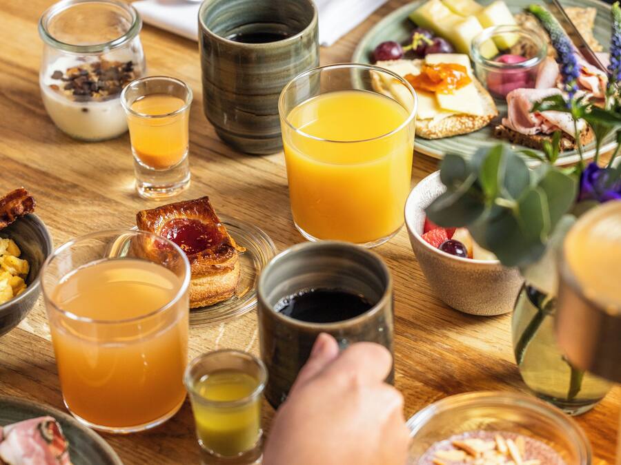 Un desayuno con diferentes alimentos y bebidas sobre una mesa de madera.