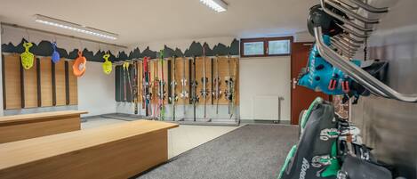 A ski rental area with wooden benches and skis on racks.