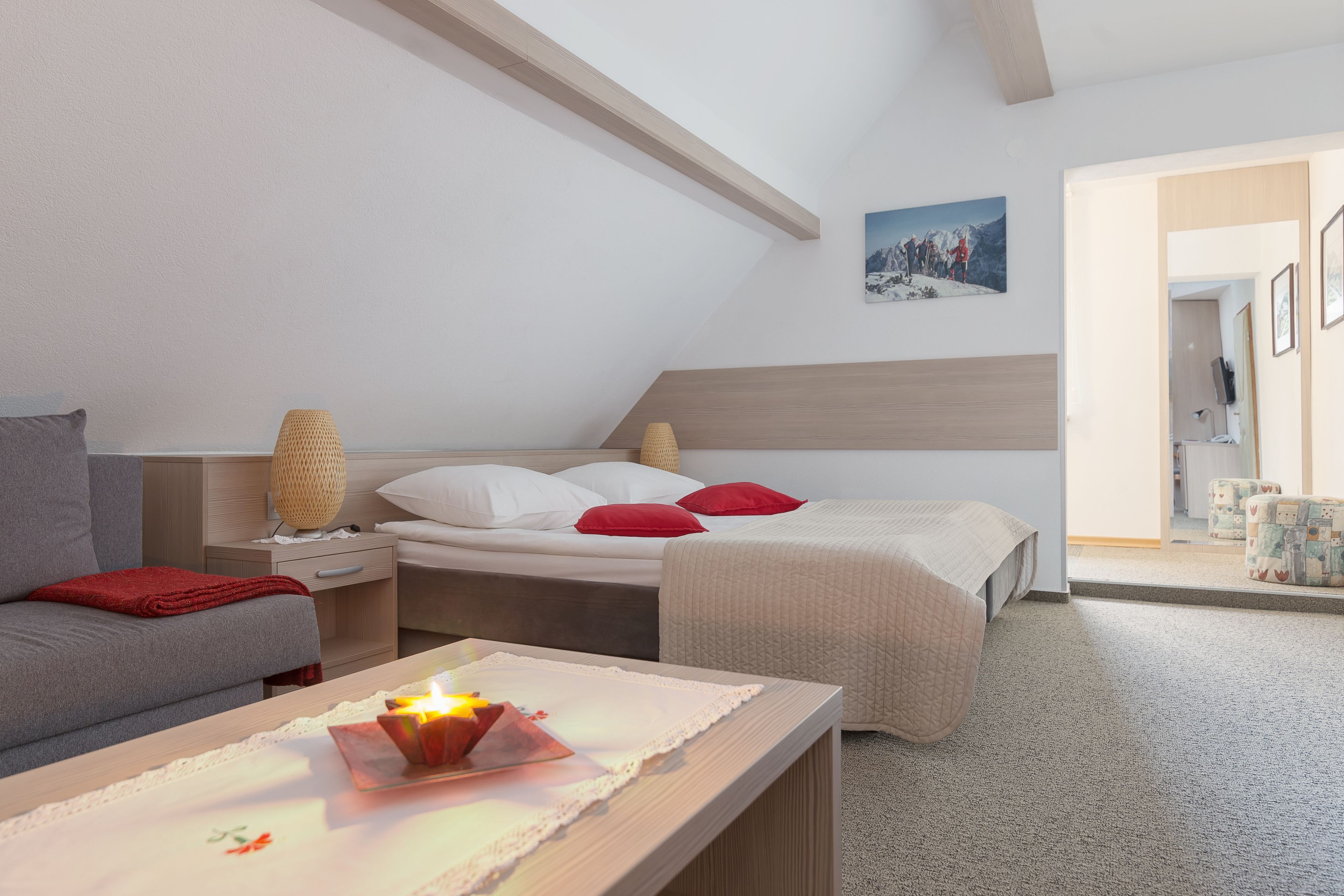 Un dormitorio con cama, mesita de noche, lámpara y un cuadro en la pared.