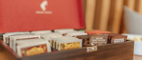 Una caja de madera con compartimentos que contienen diferentes mezclas de té.