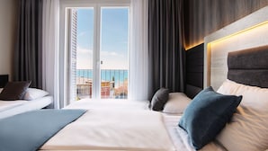 A hotel room with a large bed, two bedside tables, a view of the sea, and a balcony. - San Simon Resort Dependences (Izola)