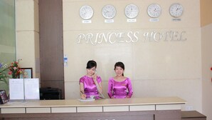 A reception desk at the Princess Hotel with clocks displaying times in Paris, Tokyo, Hanoi, London, and New York. - Princess Hotel (Da Nang)
