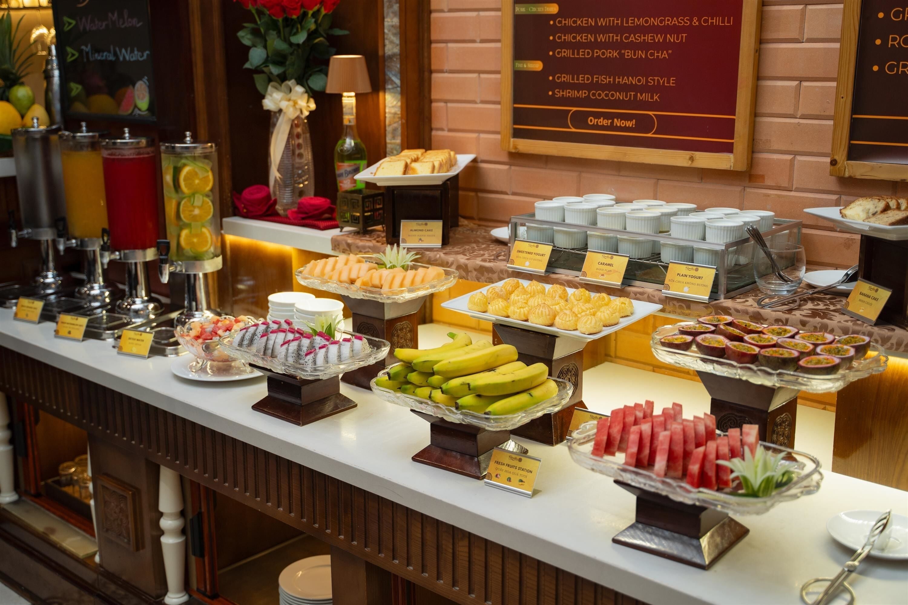 A buffet with various food options including fruits, yogurt, and desserts.