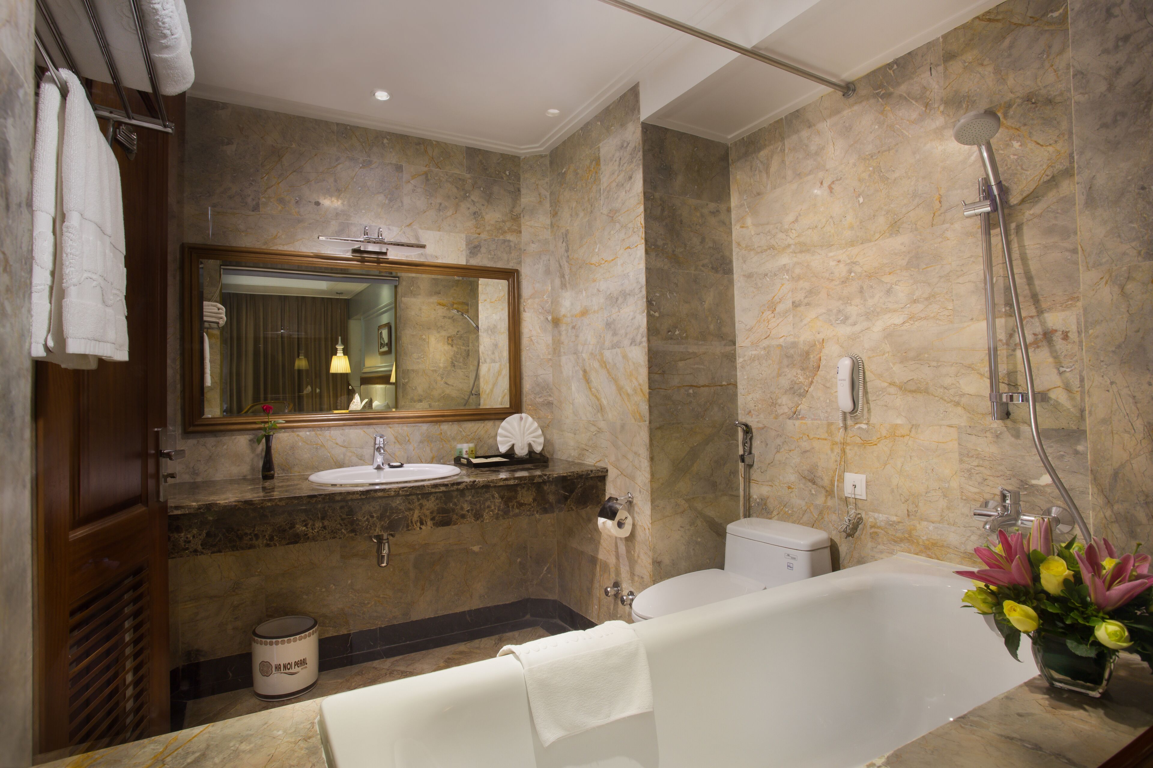 A modern bathroom with a marble sink, a bathtub, and a shower.