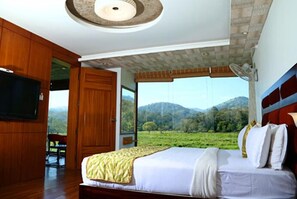Un dormitorio con una cama grande, un armario de madera y un televisor.