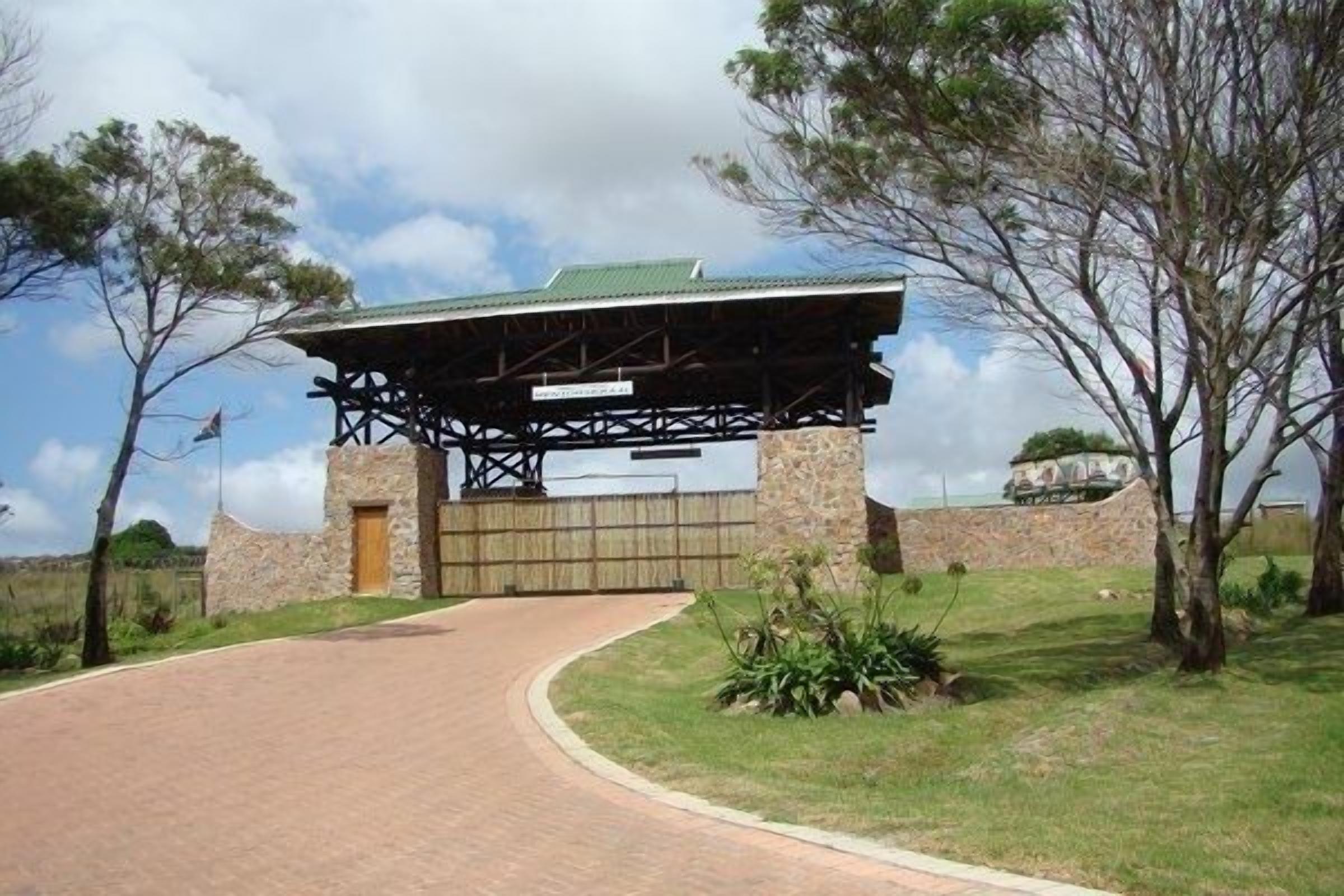 A stone building with a covered entrance and a paved driveway.