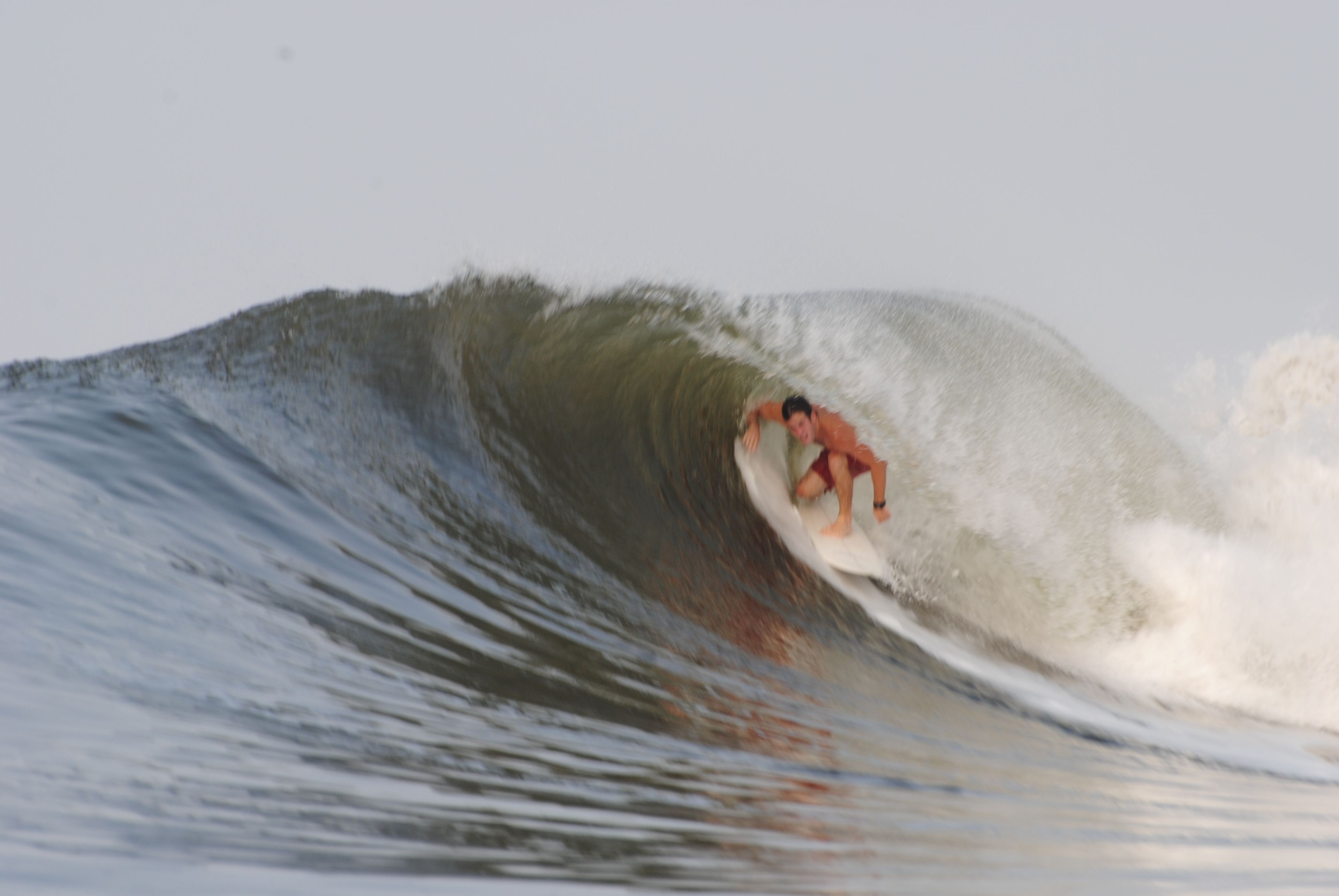 Een surfer die een grote golf rijdt.