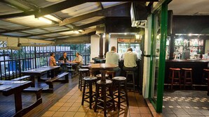 A restaurant with outdoor seating, a bar area, and a view through the windows. - Digger Inn (Francistown)