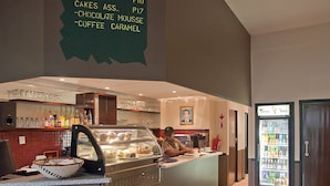 A bakery counter with a menu listing items like rolls, muffins, and coffee. - Digger Inn (Francistown)
