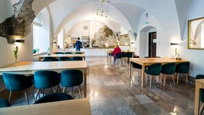 A spacious dining area with high ceilings and arched alcoves, featuring modern furniture and a central island. - Dom Na Podwalu Lublin  (Lublin)