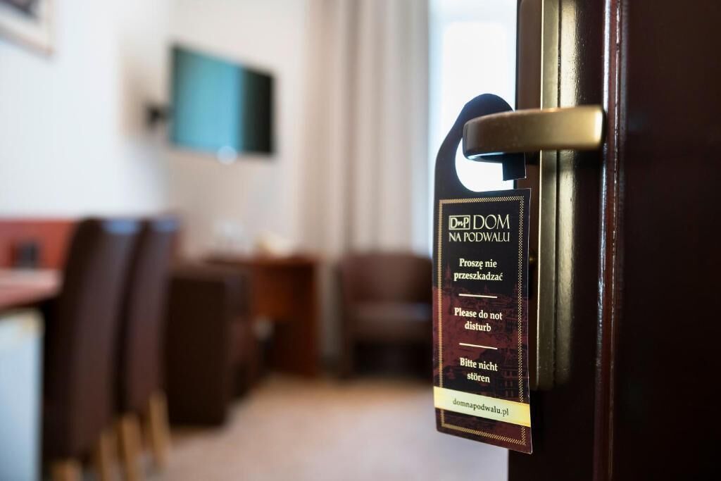 Een hotelkamerdeur met een bordje in verschillende talen waarop gasten verzocht worden niet te storen.