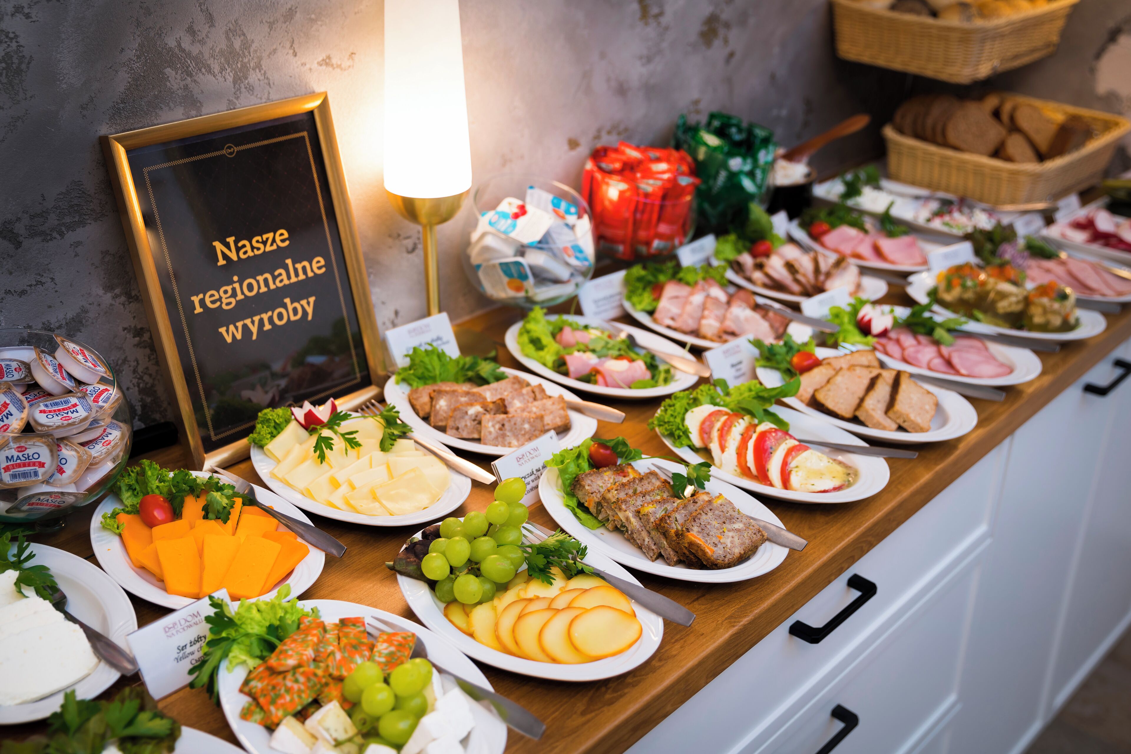 Una mesa de buffet con diversos alimentos y un cartel que dice "Nasze regionalne wyroby".