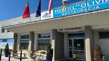 A hotel named 'Hotel Olivia' with a sign indicating a restaurant and a reception area.