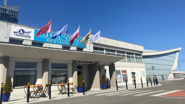 A building with a sign for 'OTEL CIVI RESTAURACJA' and multiple flags. - Hotel Olivia (Gdańsk)