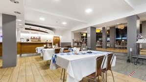 A hotel dining area with tables set for guests, a reception desk, and a view of the lobby. - Hotel Olivia (Gdańsk)