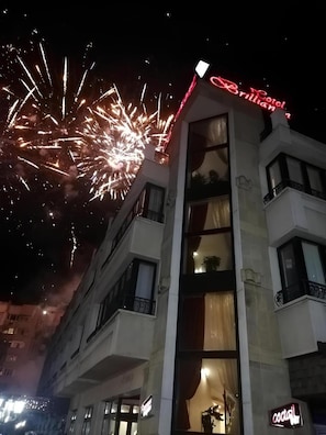 A hotel building with balconies and a neon sign indicating a bar. - Hotel Brilliantin (Sliven)