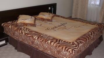 Una cama con una colcha de estampado de cebra y un cojín decorativo con un nombre.