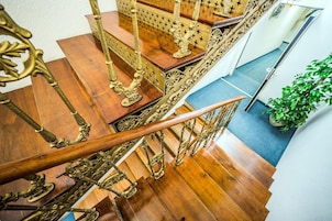 Una escalera de madera con barandales de latón ornamentados y un pasamanos.