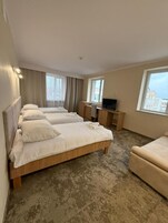 Una habitación de hotel con una cama grande, un escritorio, una silla y un televisor.