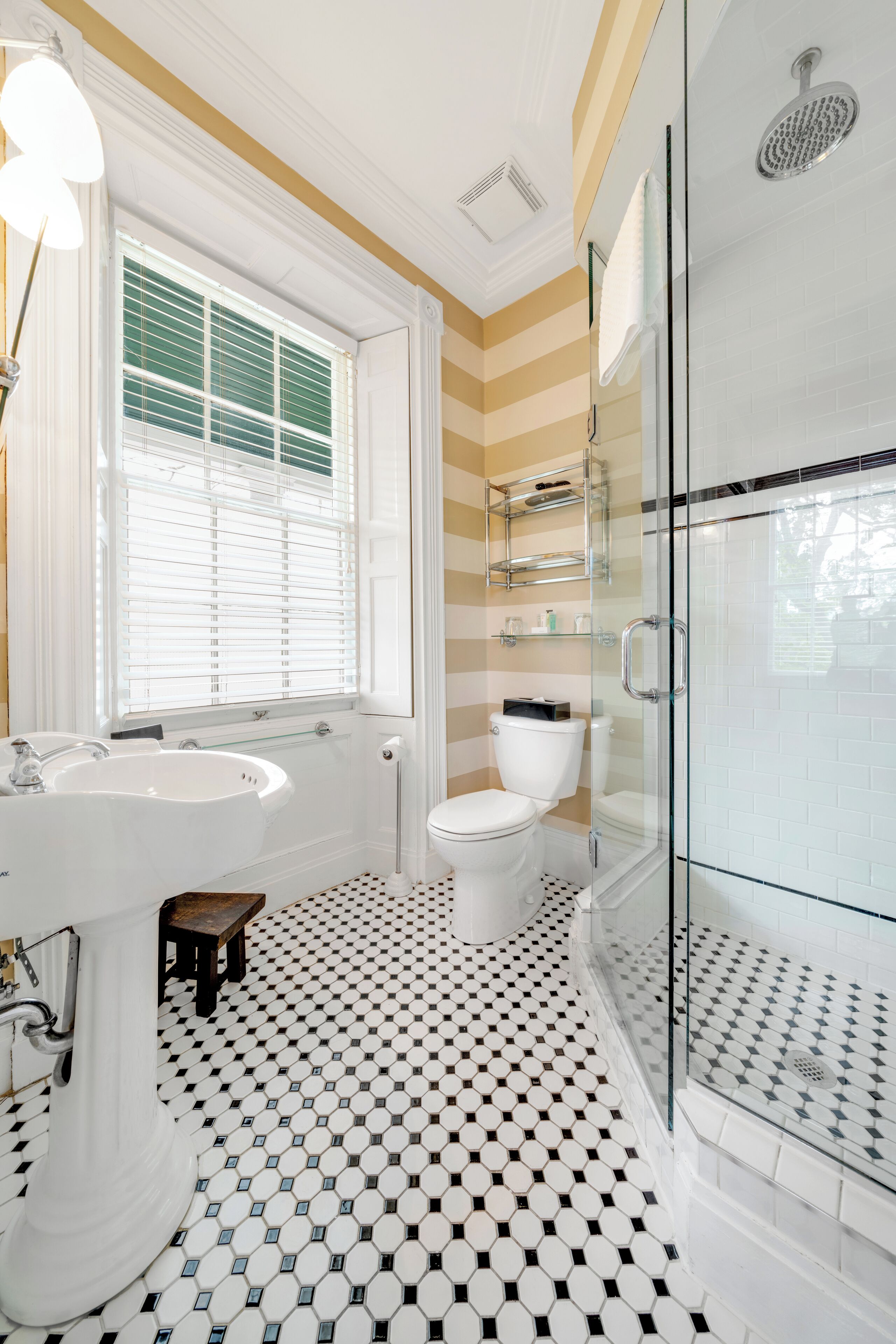 A bathroom with a white sink, toilet, and glass-enclosed shower.