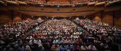 A large auditorium with tiered seating and a stage at the front.