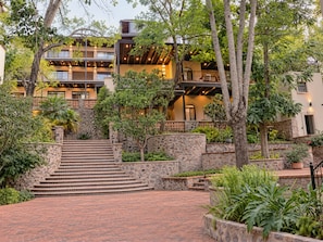 Un edificio de varios pisos con una escalera de piedra que conduce a una zona de entrada plana.