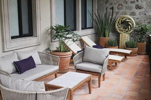 Un espace extérieur aménagé avec des meubles en osier et des plantes en pot.