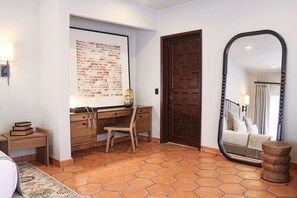 Ein Zimmer mit Schreibtisch, Stuhl und einem großen Spiegel.