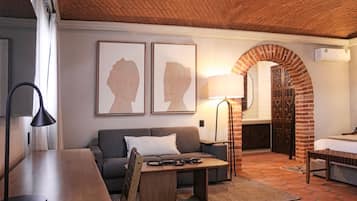 Una habitación acogedora con techo de ladrillo, un sofá, una mesa y una lámpara.