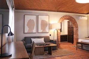 Una habitación acogedora con techo de ladrillo, un sofá, una mesa y una lámpara.
