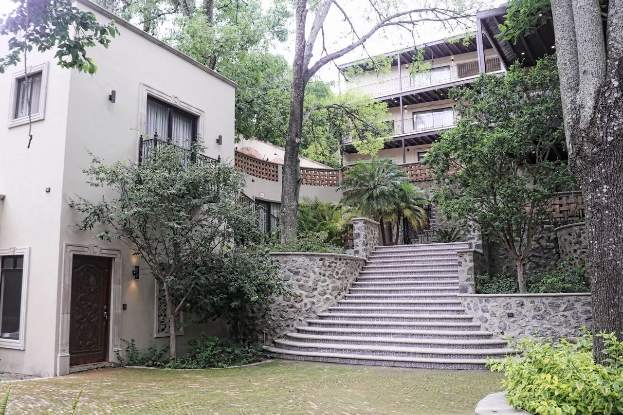 Un edificio de varios pisos con una escalera de piedra que baja a un nivel inferior.