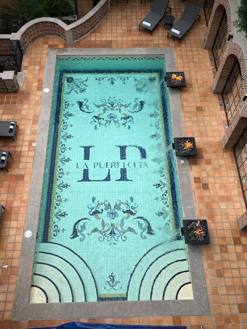 Una piscina con baldosas decorativas y el texto 'LA PUERTO' en las paredes.