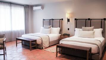 Una habitación de hotel con dos camas, un escritorio y una silla.