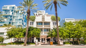 A hotel with a modern facade, palm trees, and a clear blue sky. - Iberostar Waves Berkeley Shore (Miami Beach)