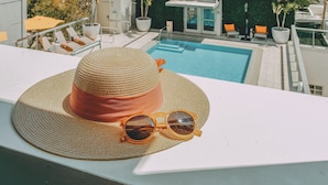 A rooftop pool area with a lounge chair, a sun hat, and sunglasses. - Iberostar Waves Berkeley Shore (Miami Beach)