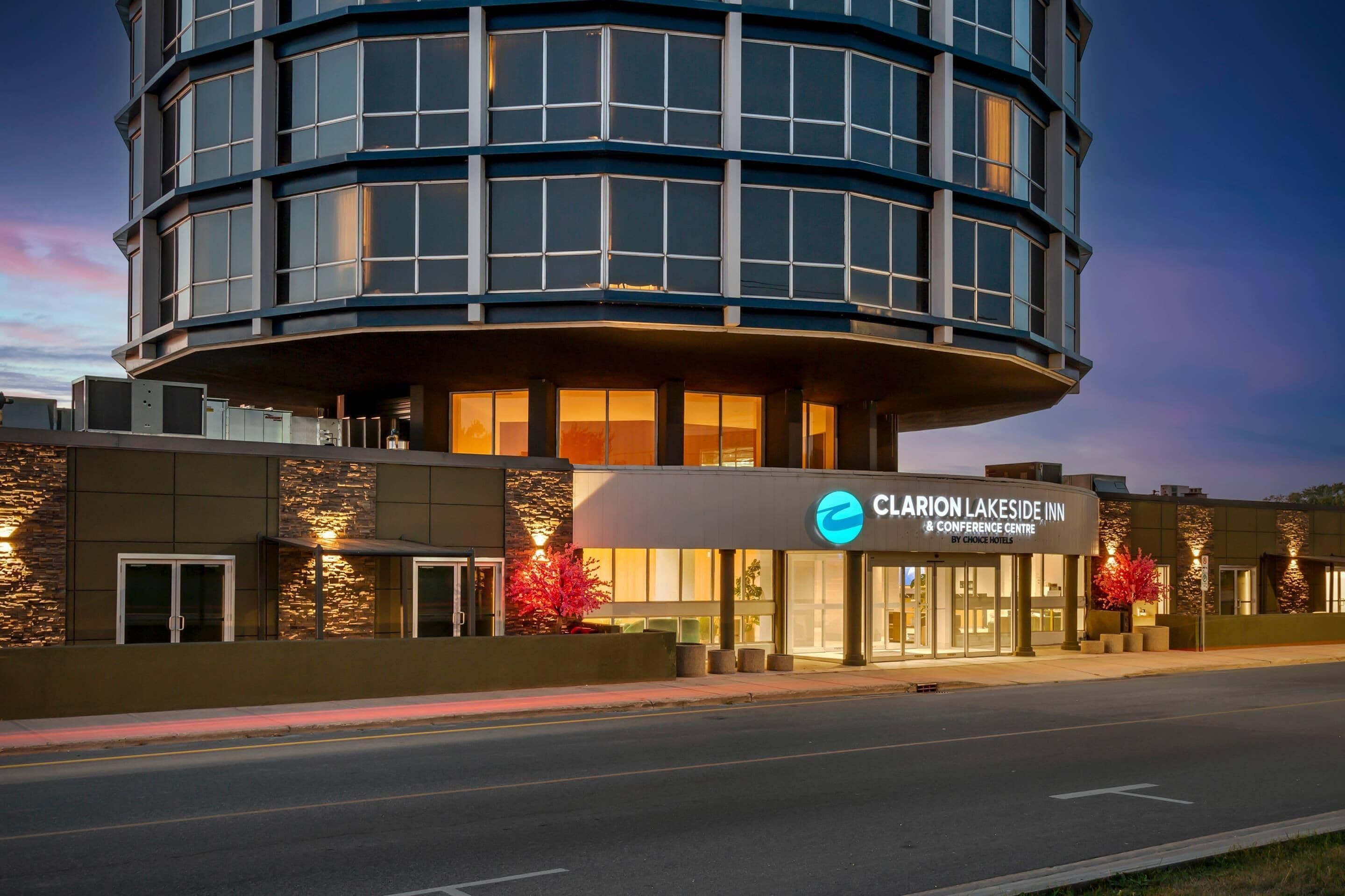 Un hôtel moderne à la façade incurvée, doté de grandes fenêtres et d’une enseigne bien visible pour le Claron Lakeside Inn & Conference Centre.