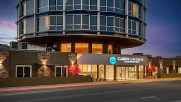 A modern hotel with a curved facade, large windows, and a prominent signage for Claron Lakeside Inn & Conference Centre.
