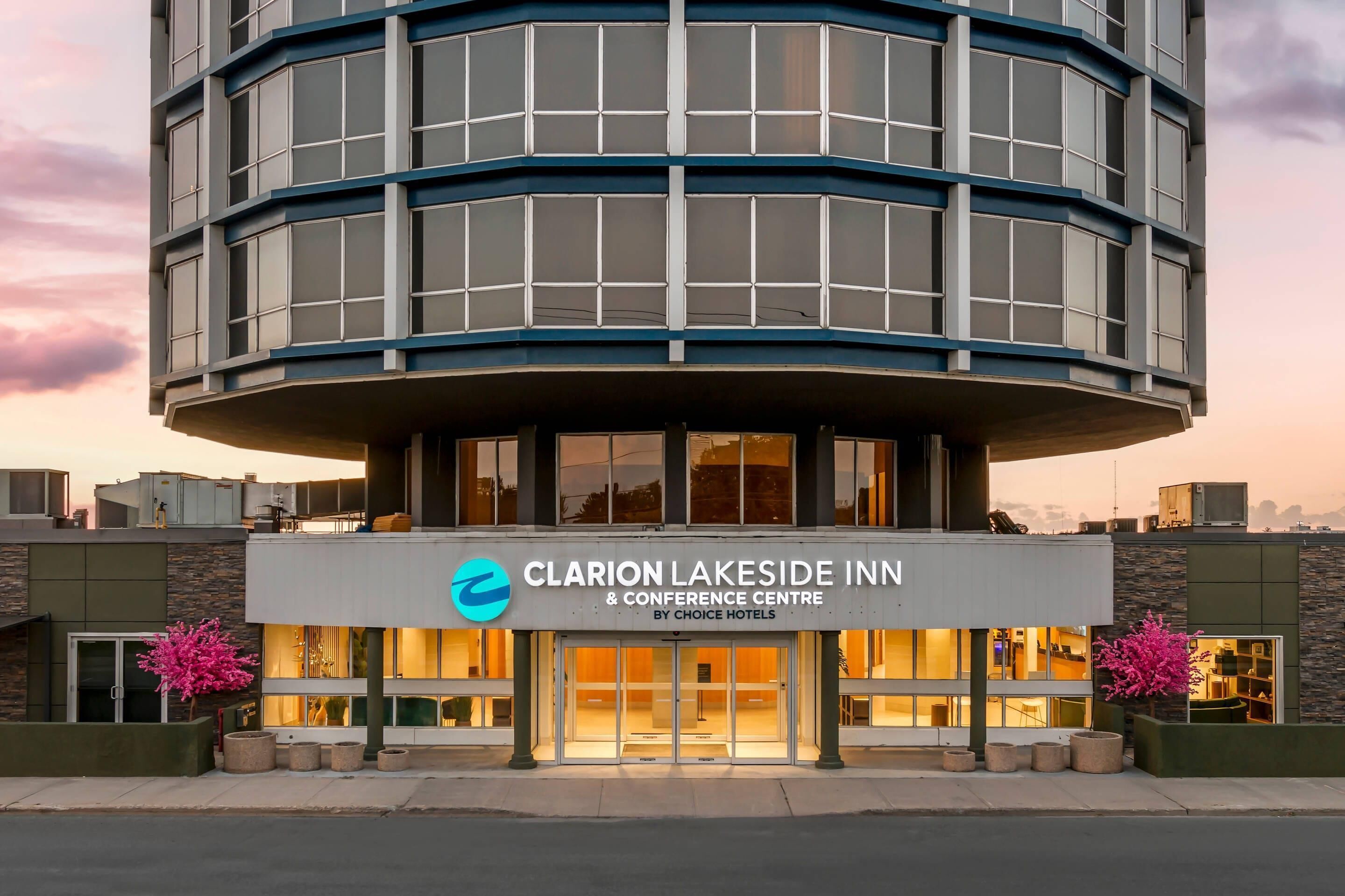 The Clarion Lakeside Inn & Conference Centre by Choice Hotels with a modern architectural design, featuring a prominent entrance and visible interior lighting.