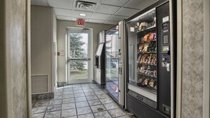 A hallway with vending machines and an exit door. - Motel 6 London, ON - Ontario (London)