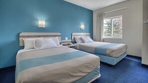 A hotel room with two beds, a large window with curtains, and a blue carpet. - Motel 6 London, ON - Ontario (London)