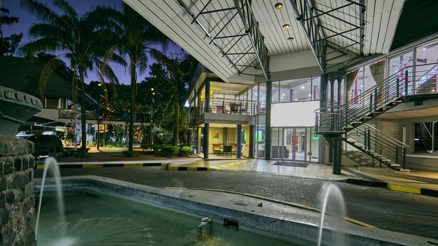 Ein modernes Hotel mit Pool, Außenbereich und überdachtem Gang.