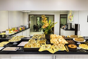 A buffet with various food items and a decorative plant.