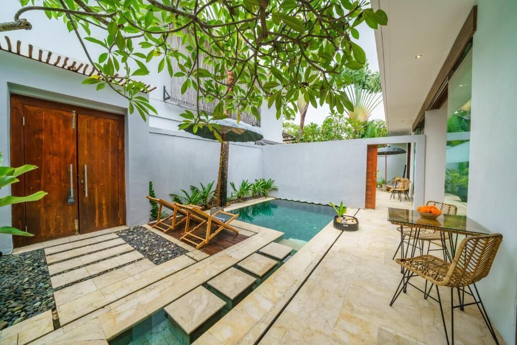 Ein moderner Poolbereich im Freien mit Holzterrasse, Liegestühlen und einem Esstisch mit Stühlen.